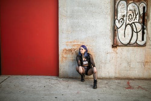 黑色背心和黑色短裤，坐在灰色的水泥地板上的女人 · 免费素材图片