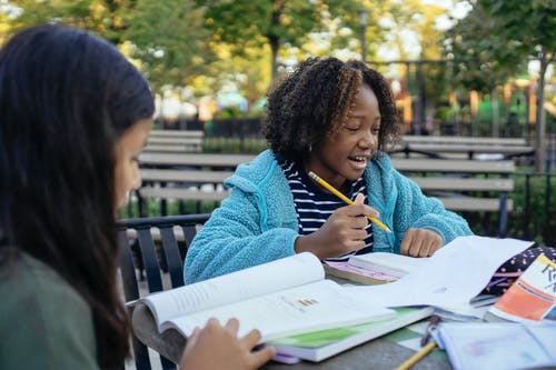 性格开朗的非洲裔美国女孩和朋友一起学习 · 免费素材图片