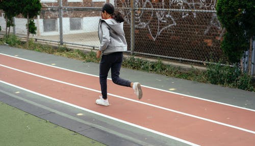 在运动场上慢跑的不露面女孩 · 免费素材图片