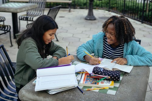 性格开朗的多种族的小女孩在一起做作业 · 免费素材图片