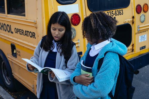 校车附近的多种族小女孩 · 免费素材图片