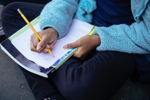 聪明勤奋的族裔孩子在纸上做作业 · 免费素材图片