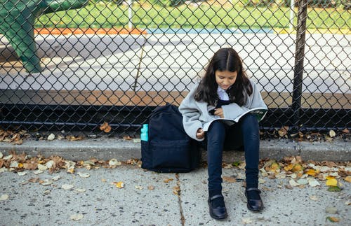 重点突出的女孩在街上读书教科书 · 免费素材图片