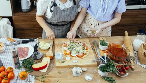 切片披萨的白色和黑色条纹衬衫的女人 · 免费素材图片
