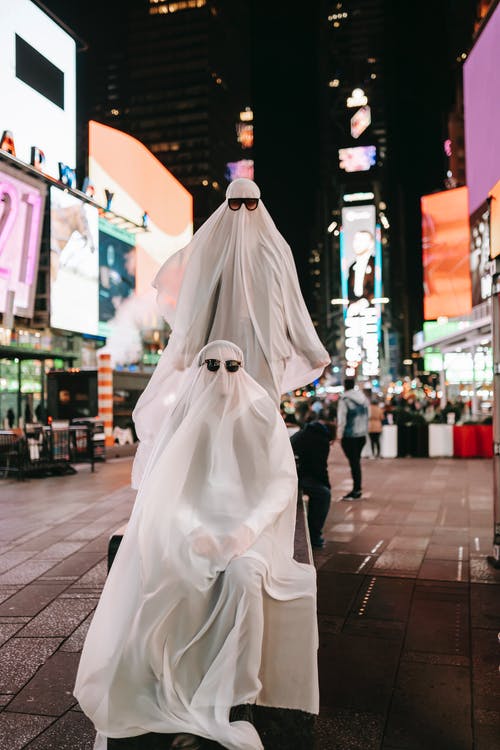 晚上在人行道上行走的白色连衣裙的人 · 免费素材图片