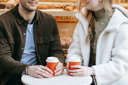 男人和女人拿着红色和白色的咖啡杯 · 免费素材图片