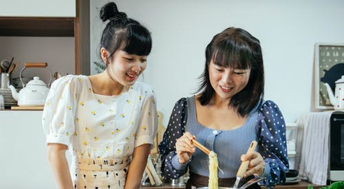 黑色和白色圆点衬衫的女孩在白色和黄色圆点的女孩旁边 · 免费素材图片
