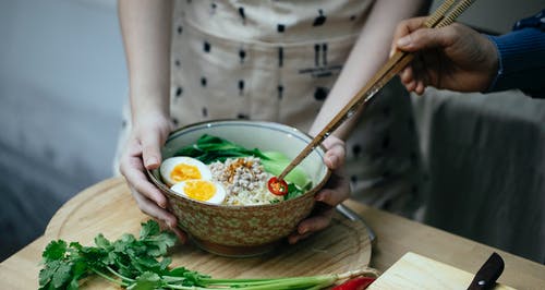 绿色和白色陶瓷碗上的棕色筷子 · 免费素材图片