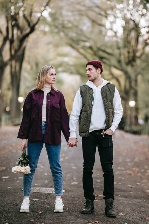 白色礼服衬衫的男人和紫色夹克在大街上行走的女人 · 免费素材图片