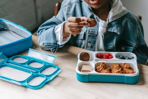 牛仔布的黑人男孩在塑料容器中吃美味的早餐 · 免费素材图片