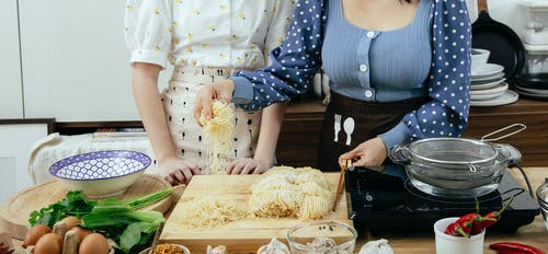 拿着一束鲜花的蓝色和白色的圆点连衣裙的女人 · 免费素材图片