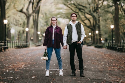 黑夹克的男人站在紫色围巾的女人旁边 · 免费素材图片