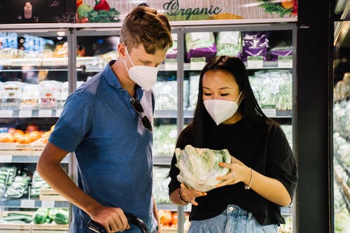 夫妇与口罩买新鲜的蔬菜 · 免费素材图片