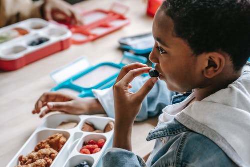 播种黑人男孩在学校吃蓝莓 · 免费素材图片