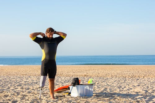 假腿在海滩上的男人 · 免费素材图片