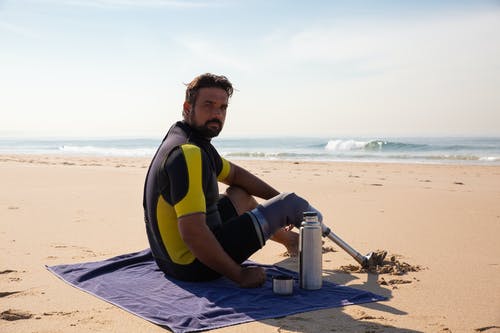 平静的民族男性截肢者，在沙滩上享受阳光明媚的日子 · 免费素材图片