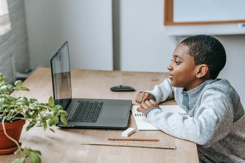 黑人男孩在笔记本电脑上观看视频 · 免费素材图片