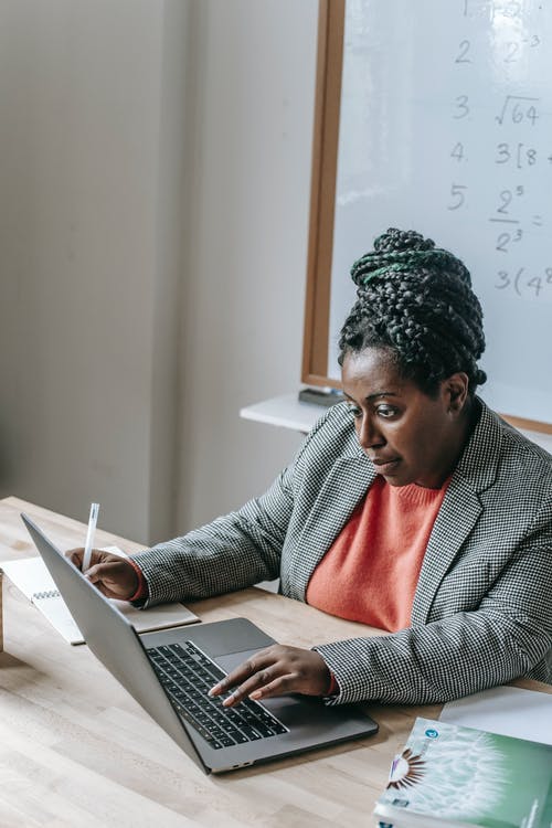在教室里的笔记本电脑上工作的黑女人 · 免费素材图片