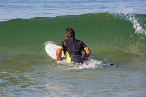 在海浪上变得面目全非的男性冲浪者腹部 · 免费素材图片