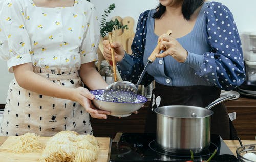拿着筷子的白色和黄色的圆点连衣裙的女人 · 免费素材图片