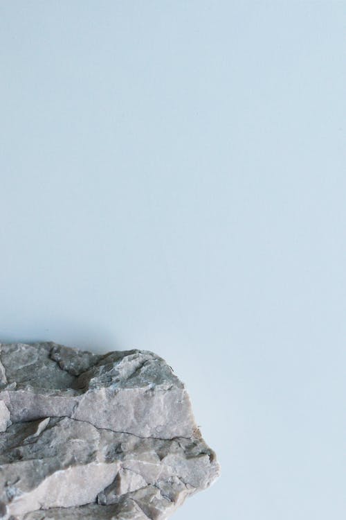 白墙旁的灰色岩层 · 免费素材图片