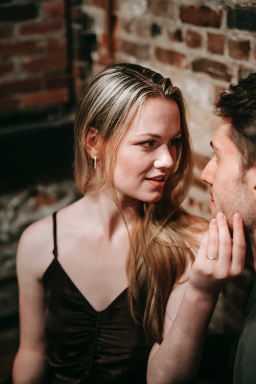 黑色意大利面条表带顶部的女人旁边黑色背心的男人 · 免费素材图片