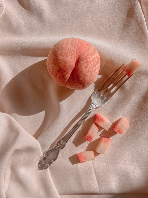 成熟的桃子，披上垂褶的织物 · 免费素材图片