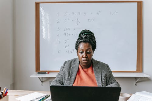 严肃的黑人老师在笔记本电脑上在线给数学 · 免费素材图片
