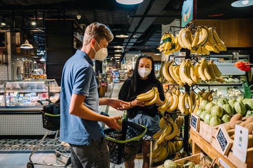 几个戴着口罩买新鲜香蕉 · 免费素材图片