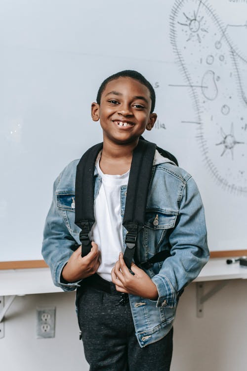 站立在白板附近的快乐的黑人孩子在教室 · 免费素材图片