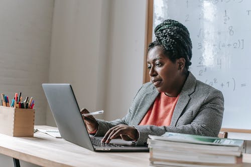 黑人妇女在与膝上型计算机的桌上 · 免费素材图片