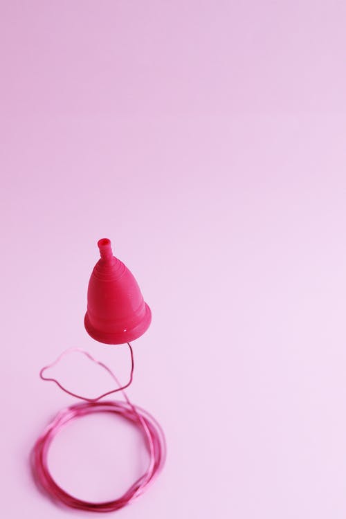 粉红色纺织上的粉红色塑料杯 · 免费素材图片