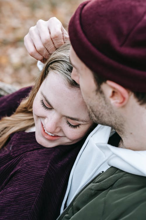 栗色男人针织毛衣亲吻白夹克的女人 · 免费素材图片