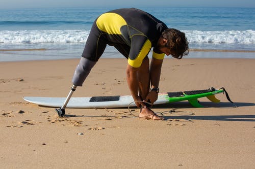 适合截肢男性冲浪者绑在脚踝周围的冲浪板皮带 · 免费素材图片