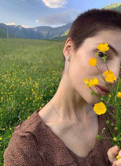 年轻女子与盛开的鲜花遮住脸 · 免费素材图片