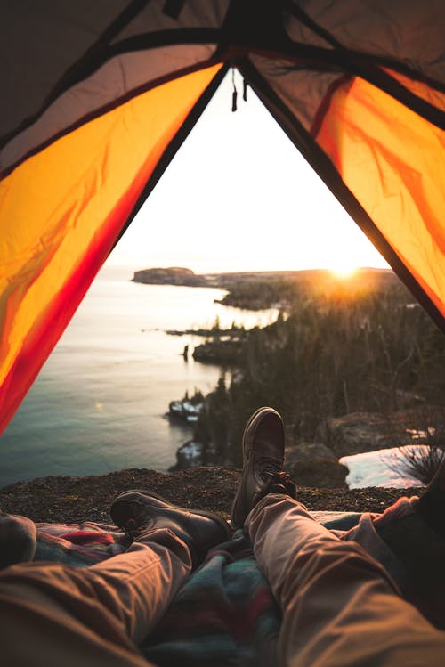 躺在岸边的野营帐篷里的游客 · 免费素材图片