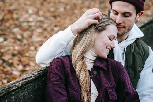 男人和女人在棕色的木凳上接吻 · 免费素材图片