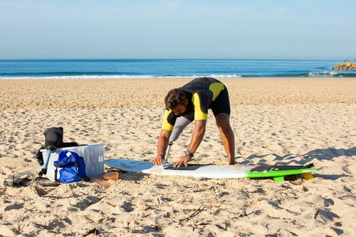 假腿准备冲浪板的男人 · 免费素材图片