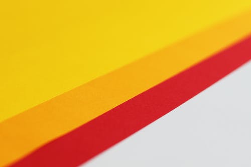 白色表面上的黄色和橙色纸 · 免费素材图片