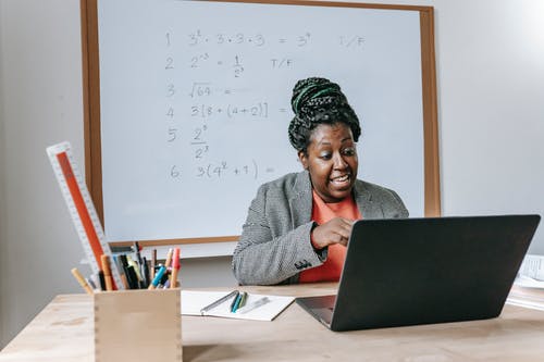 激动的黑人老师在笔记本电脑上在线解释数学 · 免费素材图片