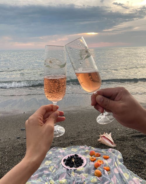 情侣在海边碰杯香槟 · 免费素材图片