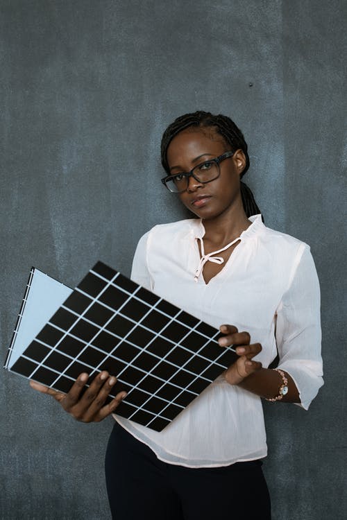 拿着蓝色和白色格仔纺织的白色长袖衬衫的女人 · 免费素材图片