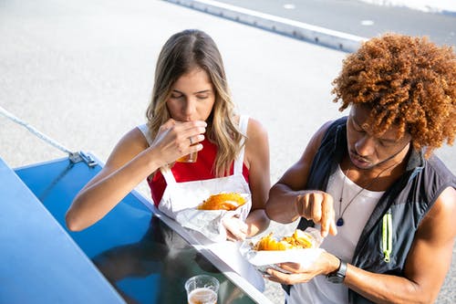 多族裔夫妇外面有啤酒和汉堡包 · 免费素材图片