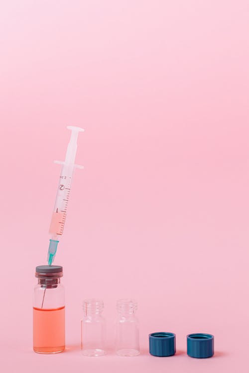 在两个小容器中转移粉红色液体 · 免费素材图片