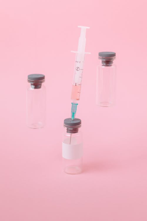 粉红色表面上的covid疫苗 · 免费素材图片