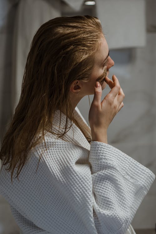 浴袍，应用在脸上的化妆品面膜的年轻女子 · 免费素材图片