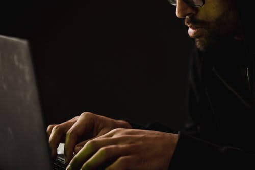 作物在黑暗中笔记本电脑上工作的大胡子的男人 · 免费素材图片