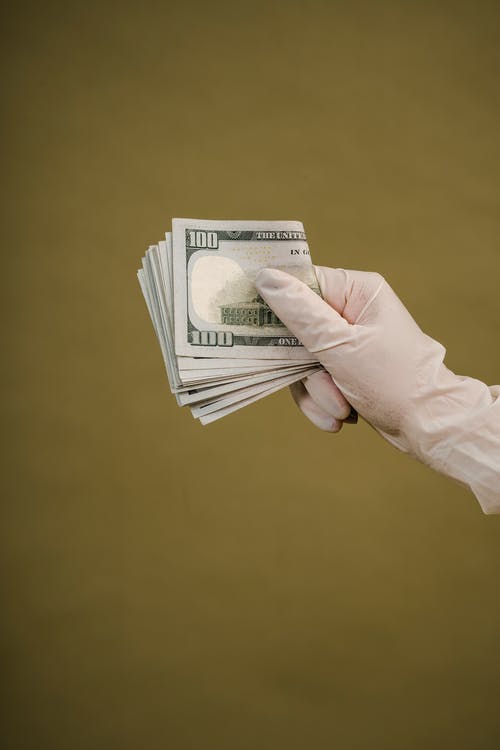 拿着美元的钞票的人的照片 · 免费素材图片