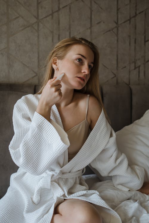 坐在床上的白色长袖衬衫的女人 · 免费素材图片