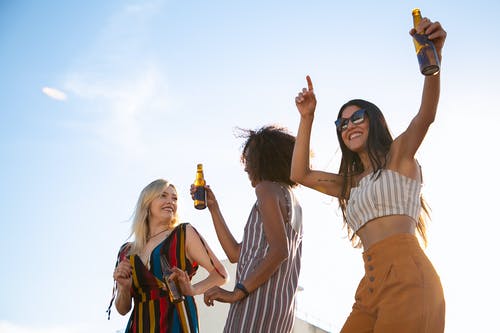 高兴的朋友在阳光明媚的露台上喝酒跳舞 · 免费素材图片